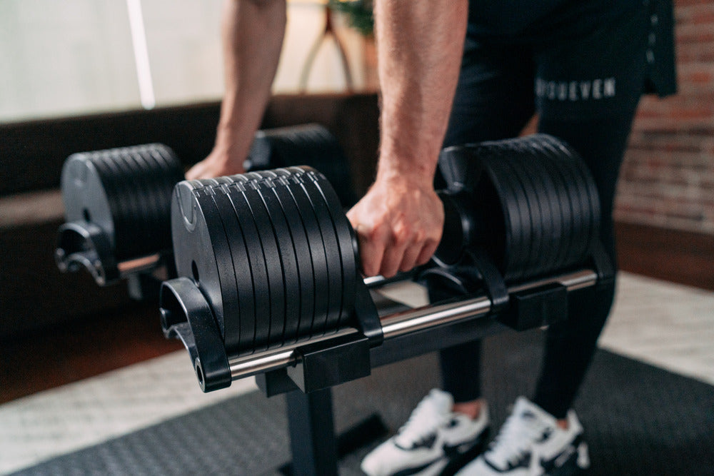 Man gripping adjustable dumbbells