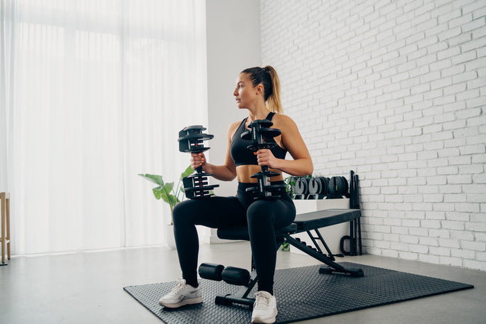 Woman using adjustable dumbbells